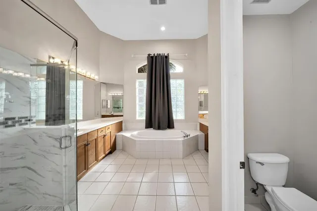 a bathroom with a granite countertop sink a toilet a mirror and shower