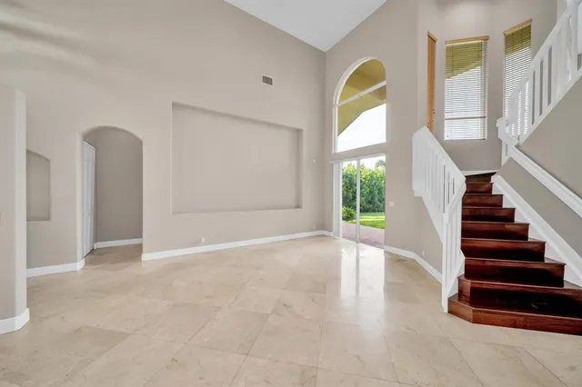 a view of empty room with wooden floor and window