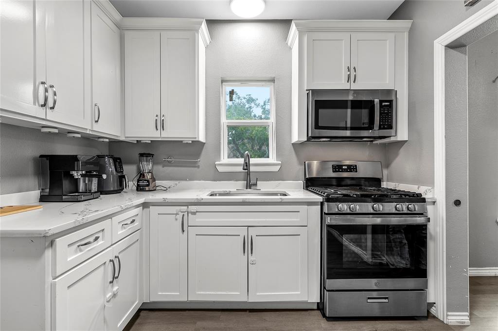 2301 Herring Avenue Waco, TX 76708 - Photo 8 of 14 a kitchen with white cabinets and a stove