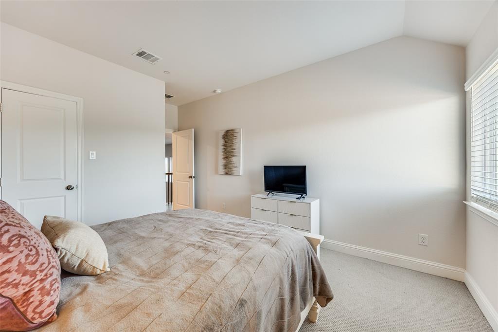 1036 Drew Lane Allen, TX 75013 - Photo 32 of 38 a bedroom with a bed and a flat screen tv