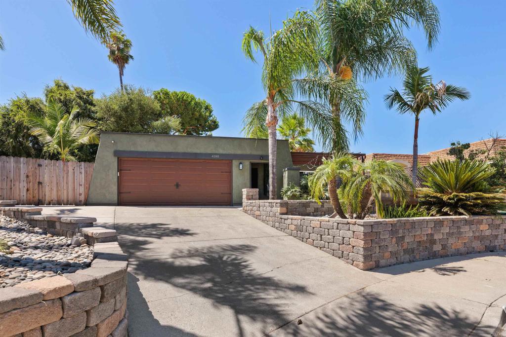 a row of palm trees in front of a house