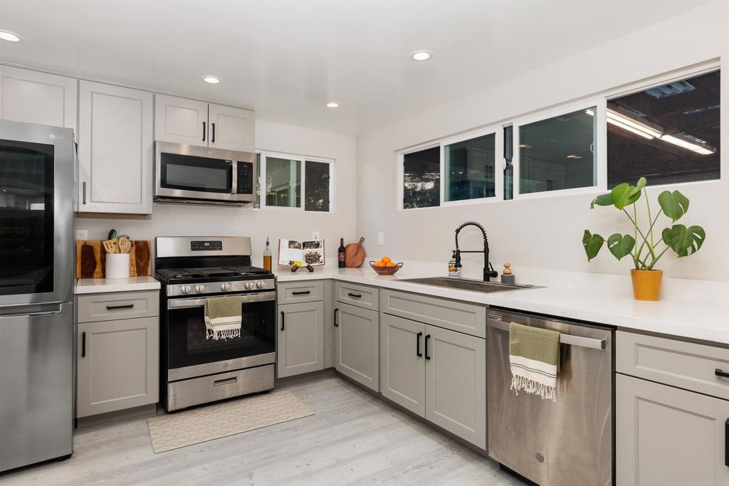 4180 Galbar Place Oceanside, CA 92056 - Photo 14 of 41 a kitchen with stainless steel appliances white cabinets a sink and a stove