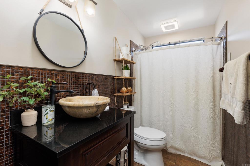 4180 Galbar Place Oceanside, CA 92056 - Photo 21 of 41 a bathroom with a toilet a sink and a mirror