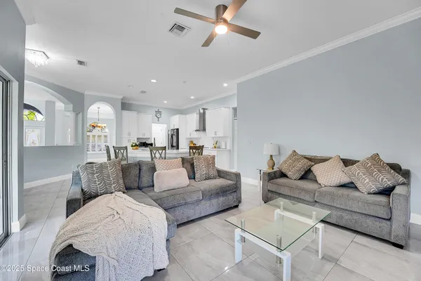 a living room with furniture and view of kitchen