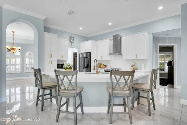 a kitchen with stainless steel appliances a dining table chairs and a refrigerator