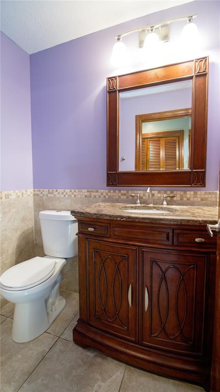 1357 Dinsmore Court New Port Richey, FL 34655 - Photo 11 of 60 a bathroom with a granite countertop toilet sink and mirror