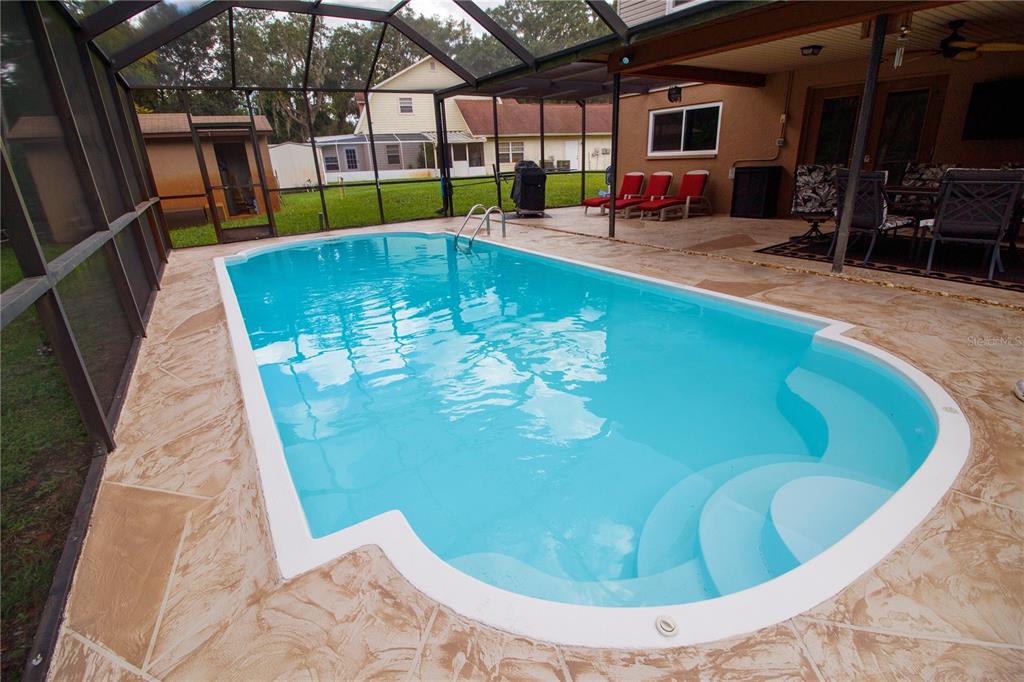 1357 Dinsmore Court New Port Richey, FL 34655 - Photo 26 of 60 a view of a swimming pool with a lounge chair