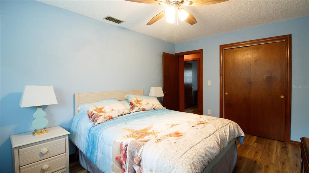 1357 Dinsmore Court New Port Richey, FL 34655 - Photo 35 of 60 a bedroom with a bed and a lamp on the dresser