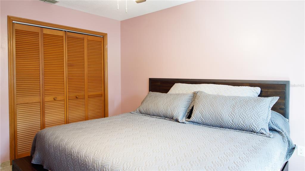 1357 Dinsmore Court New Port Richey, FL 34655 - Photo 53 of 60 a bedroom with a large bed and a night stand