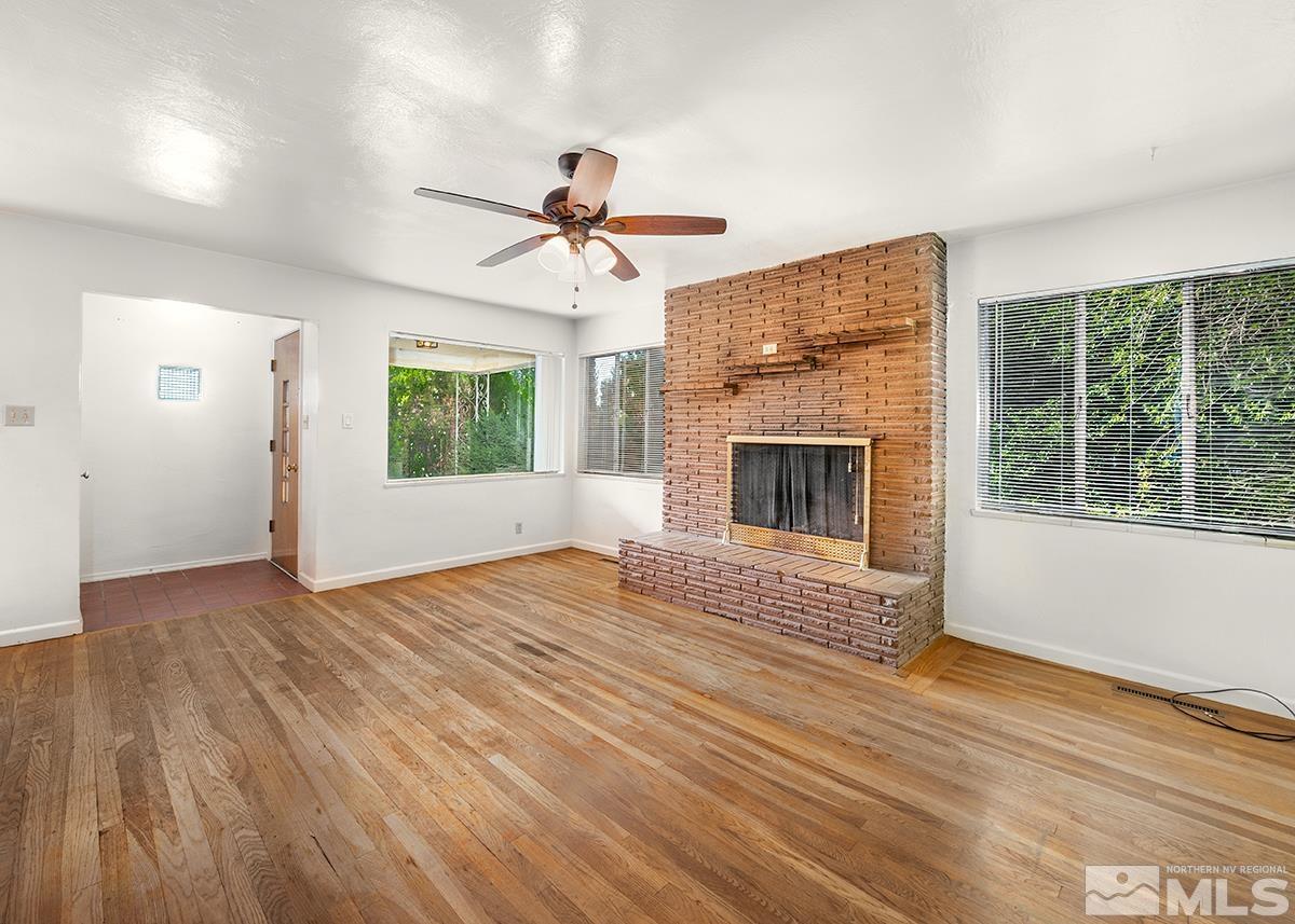 735 Brookfield Drive Reno, NV 89503 - Photo 4 of 23 an empty room with windows fireplace and wooden floor