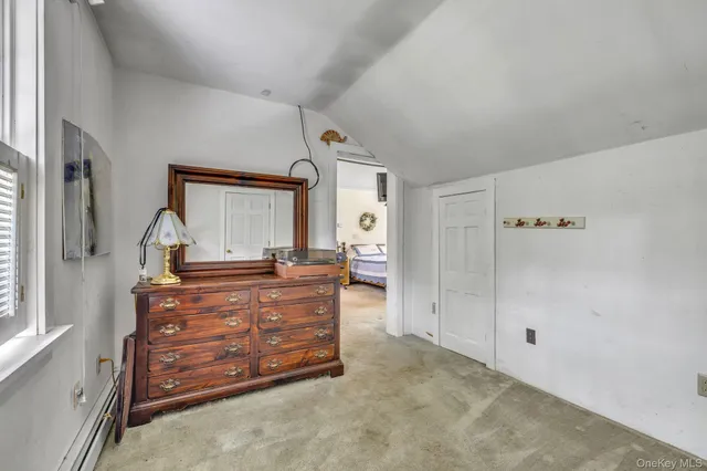 a room with a bed and a mirror on dresser