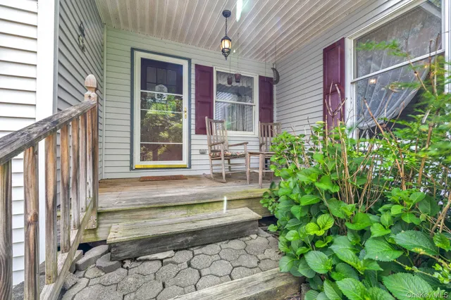a view of a house with a large windows and flower plants