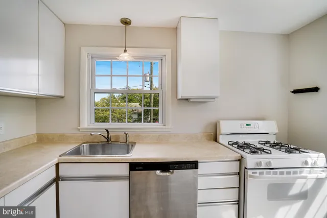 a kitchen with a sink stove top oven and cabinets