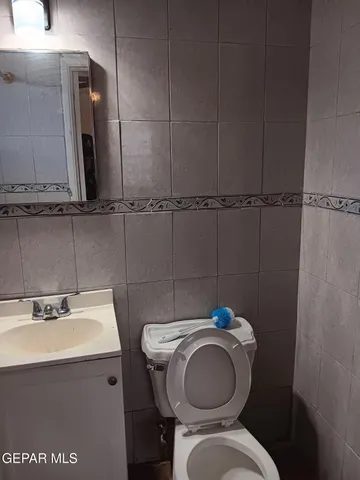 a view of an empty room with wooden floor and a ceiling fan
