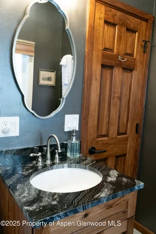 a bathroom with a granite countertop sink and a mirror
