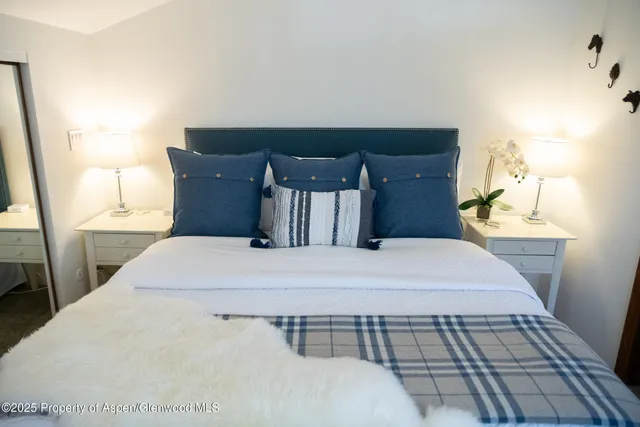 a bed sitting in a bedroom next to a window with lamp
