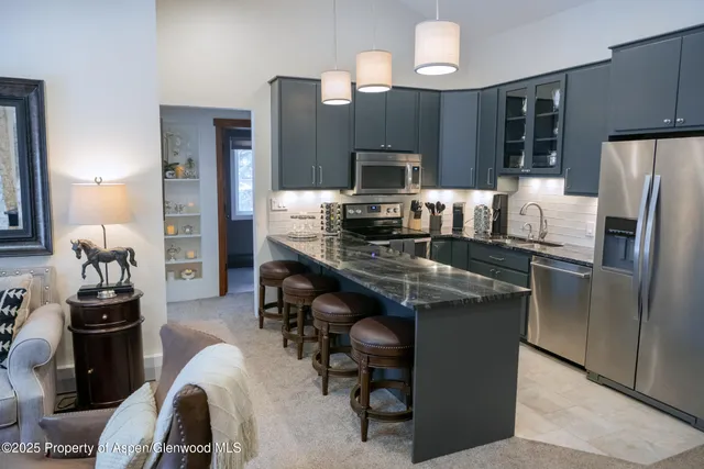 a kitchen with kitchen island a counter top space appliances and cabinets