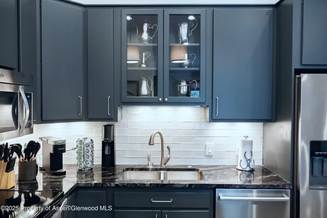 a kitchen with granite countertop a refrigerator and a sink