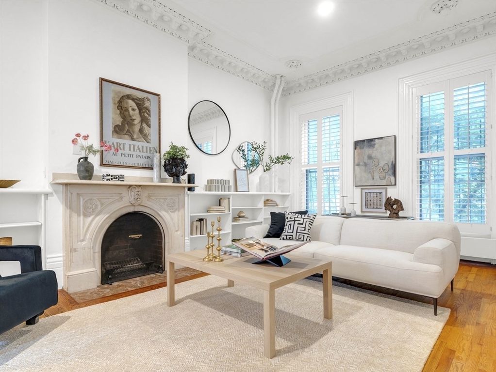 a living room with furniture a large window and a fireplace
