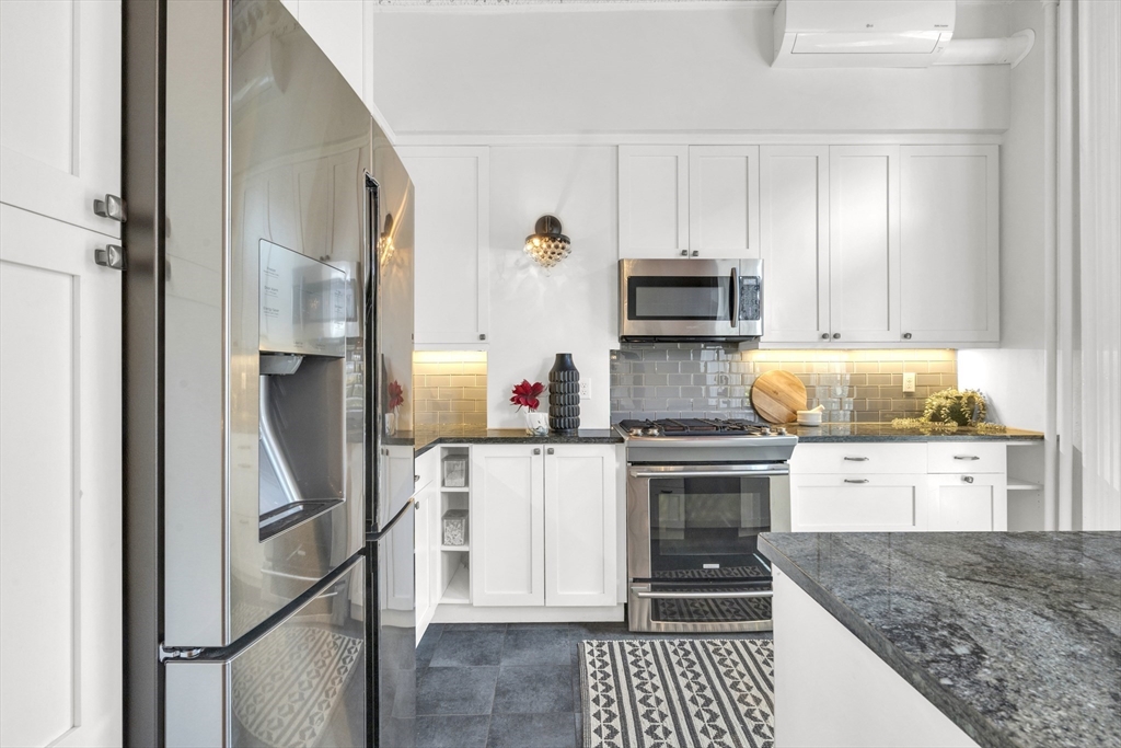 72 Rutland Street, Unit 1 Boston, MA 02118 - Photo 6 of 29 a kitchen with granite countertop a stove and a refrigerator