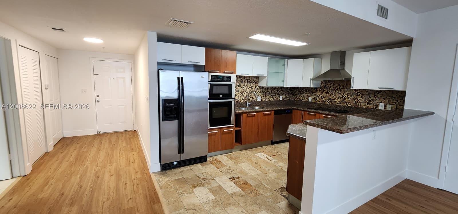 170 Southeast 14th Street, Unit 1408 Miami, FL 33131 - Photo 2 of 30 a kitchen with stainless steel appliances granite countertop a refrigerator and a stove top oven
