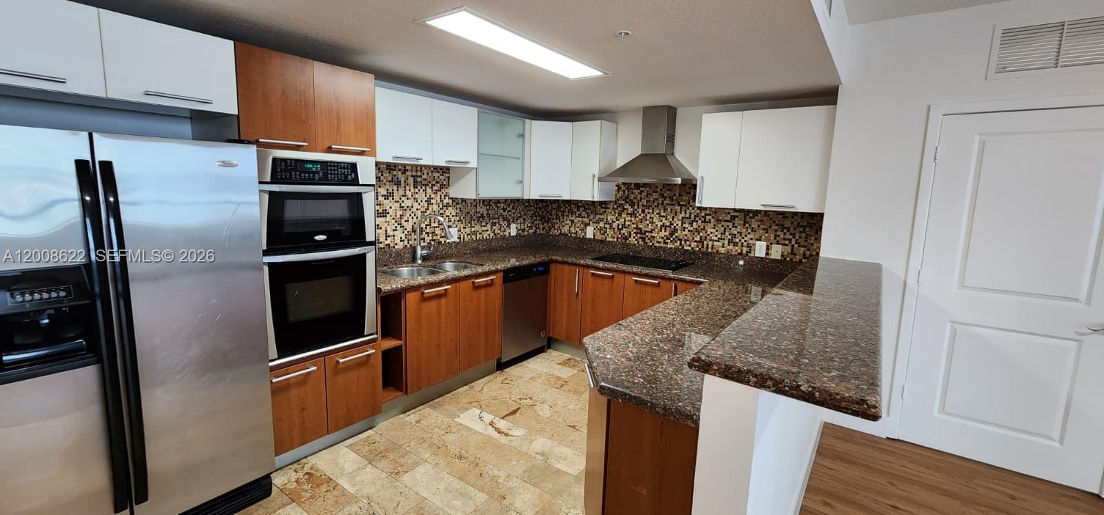 170 Southeast 14th Street, Unit 1408 Miami, FL 33131 - Photo 3 of 30 a kitchen with stainless steel appliances granite countertop a refrigerator a sink and a stove