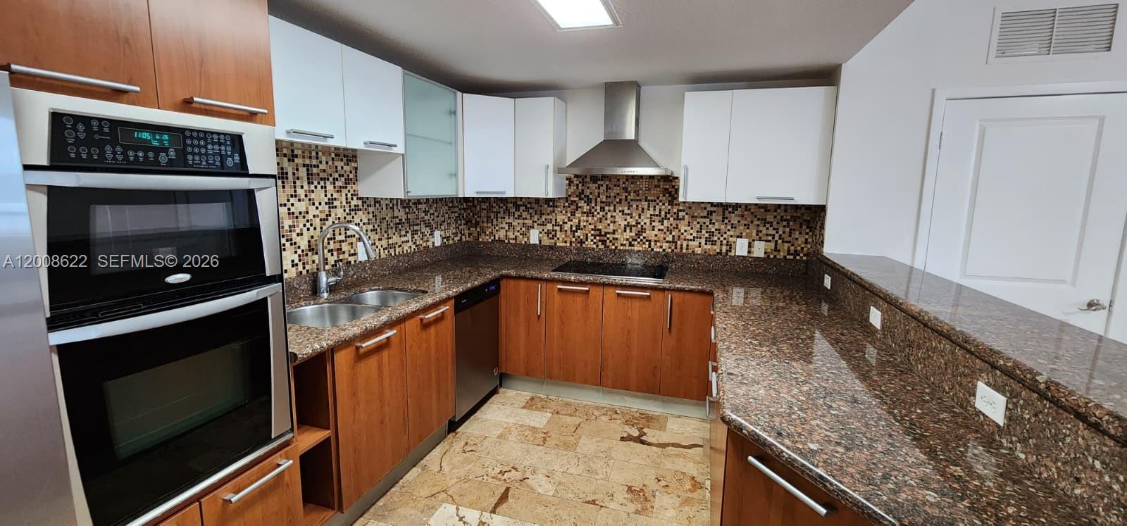 170 Southeast 14th Street, Unit 1408 Miami, FL 33131 - Photo 4 of 30 a kitchen with stainless steel appliances granite countertop a stove a sink and a microwave