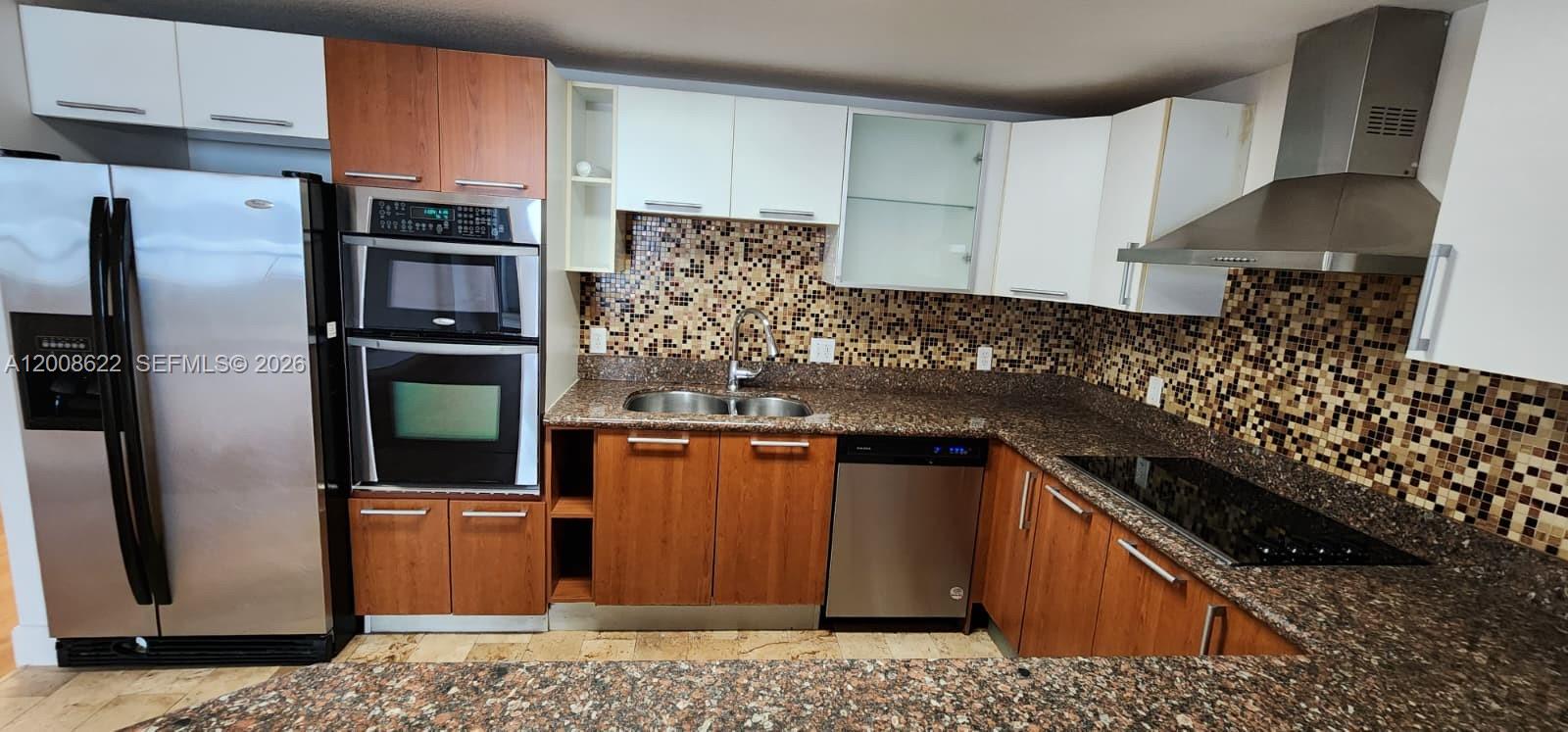 170 Southeast 14th Street, Unit 1408 Miami, FL 33131 - Photo 6 of 30 a kitchen with stainless steel appliances kitchen island granite countertop a refrigerator and a stove