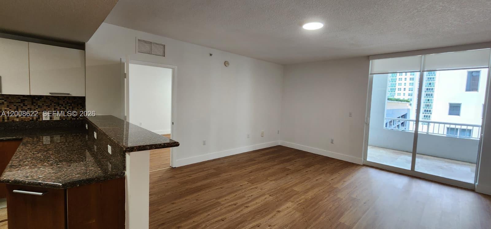 170 Southeast 14th Street, Unit 1408 Miami, FL 33131 - Photo 7 of 30 a view of an empty room with wooden floor and a window
