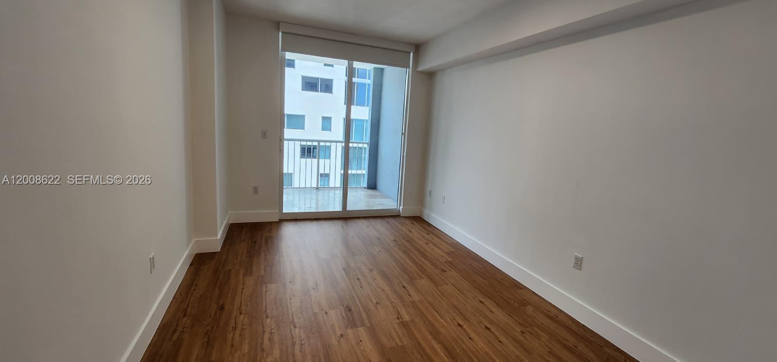 170 Southeast 14th Street, Unit 1408 Miami, FL 33131 - Photo 8 of 30 a view of an empty room with wooden floor and a window