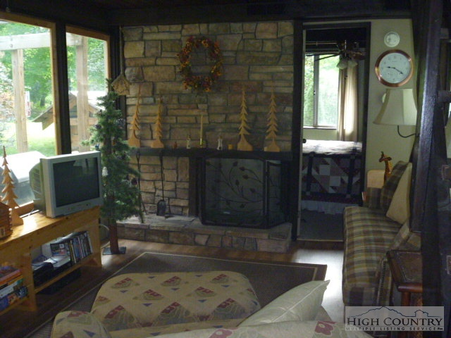 1606 Bee Tree Road Lansing, NC 28643 - Photo 6 of 9 a living room with furniture a fireplace and a flat screen tv