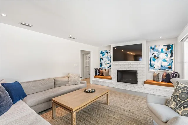 a living room with furniture a flat screen tv and a fireplace