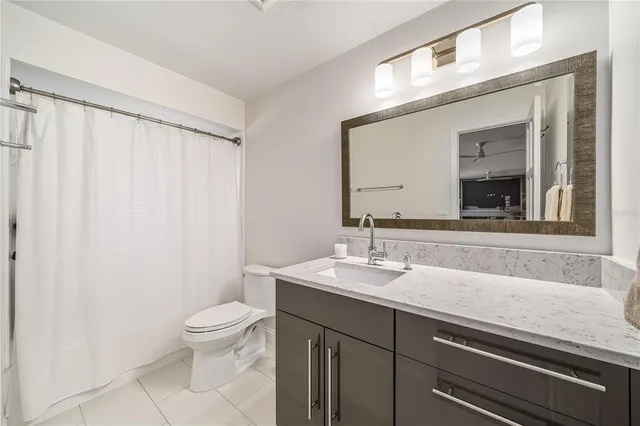 a bathroom with a granite countertop sink a toilet and a mirror