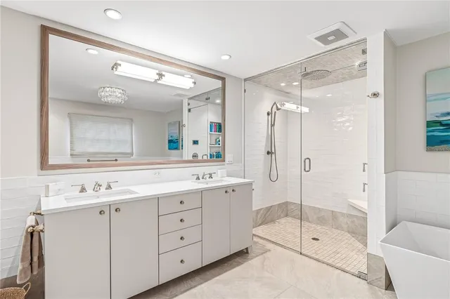 a bathroom with a double vanity sink mirror double shower and a bathtub