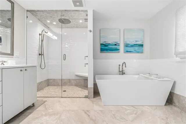 a bathroom with a tub a sink and a shower