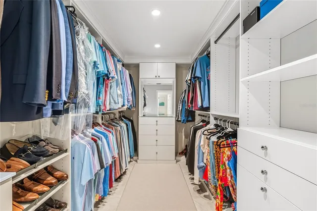 a view of walk in closet with clothes