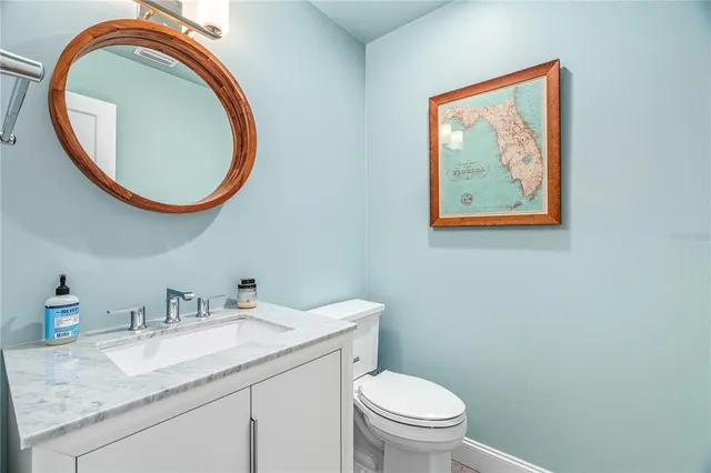 a bathroom with a granite countertop toilet a sink and a mirror