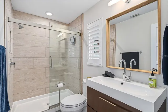 a bathroom with a sink a toilet and shower