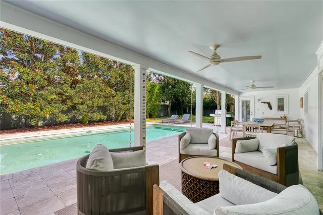 a living room with patio furniture and a large window