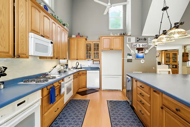 a view of a dining room with furniture a chandelier windows and wooden floor
