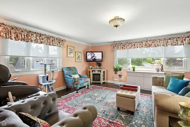 a front view of a house with a yard and a tree