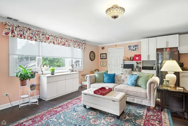 a front view of a house with a yard and a large tree