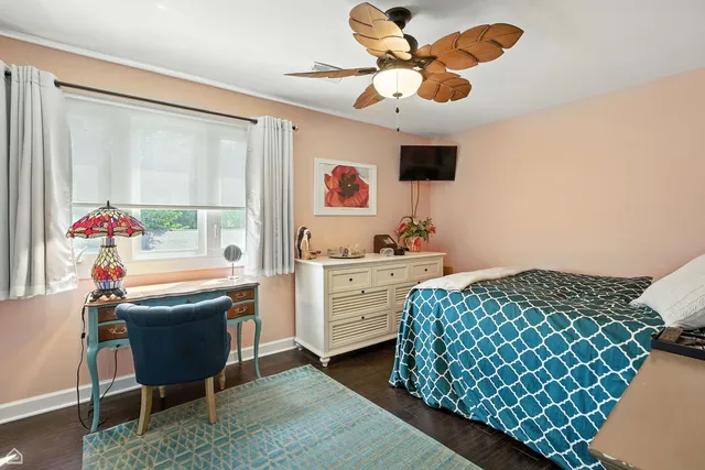 a front view of a house with a garden and trees