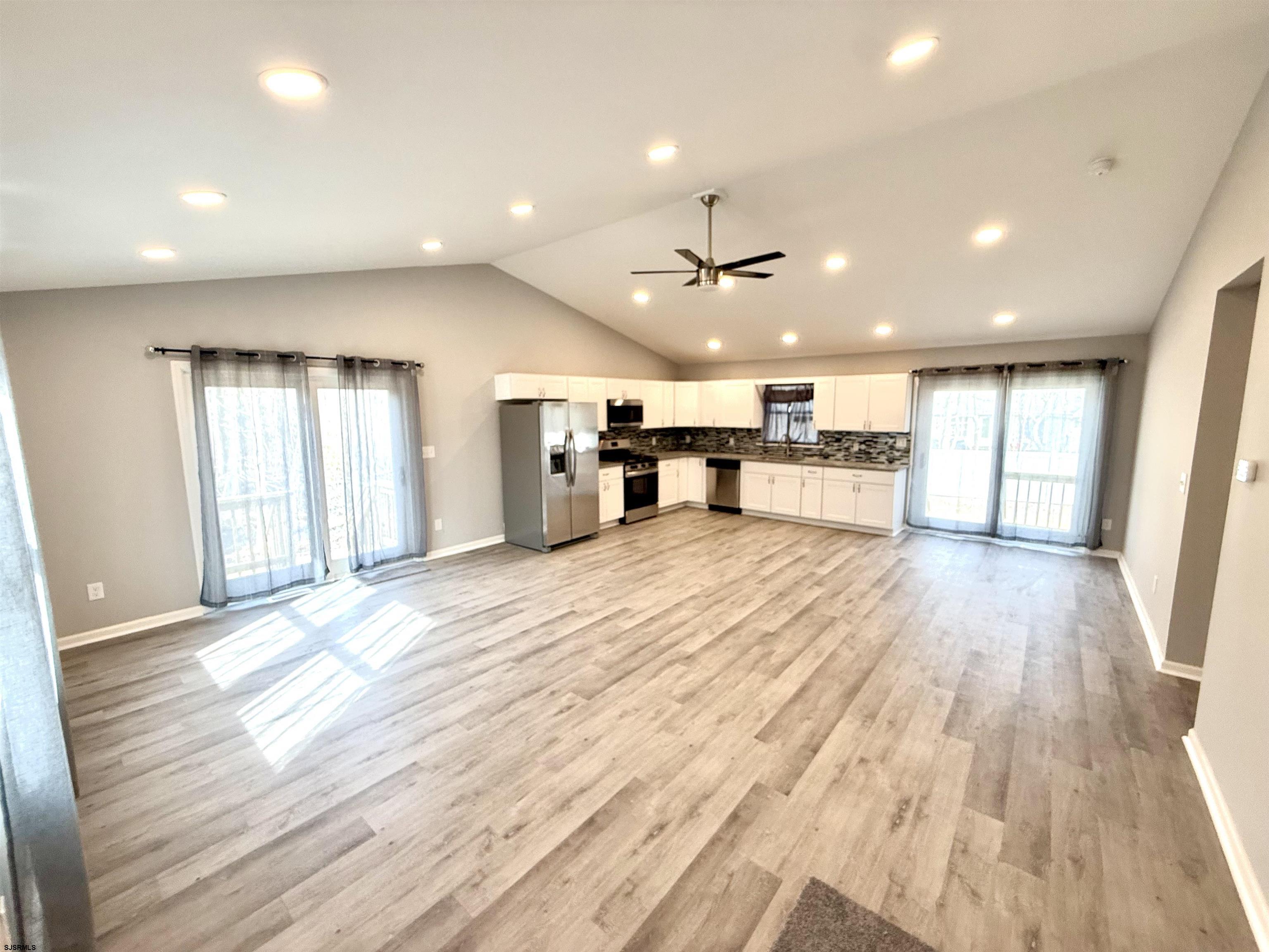 607 Sea Ranch Avenue Mays Landing, NJ 08330 - Photo 5 of 23 a view of an empty room with wooden floor and a kitchen
