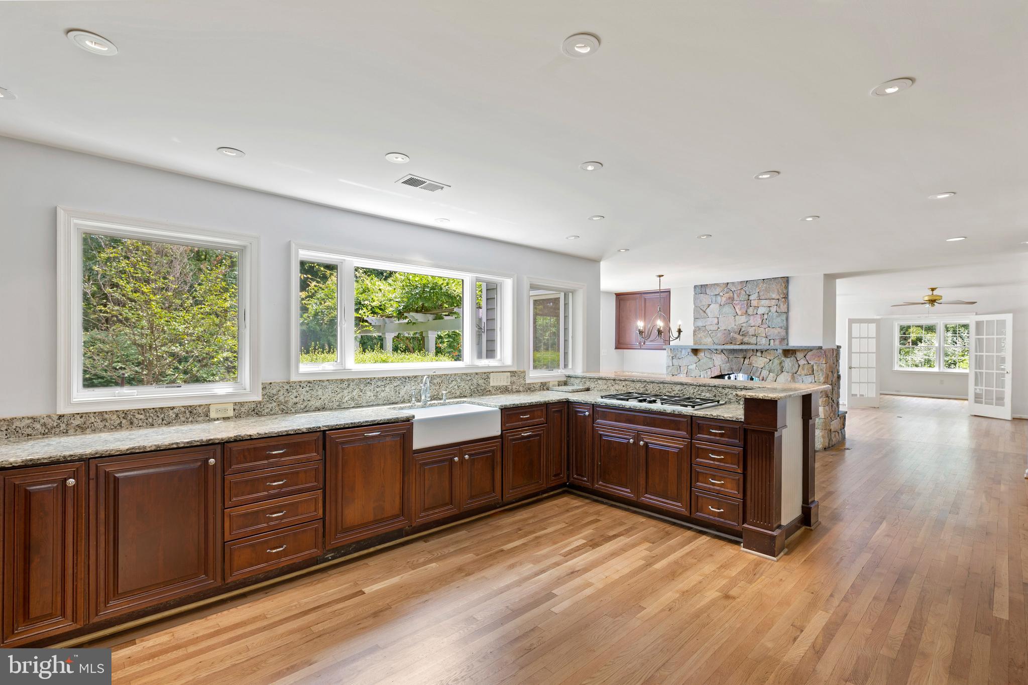 713 Clear Spring Road Great Falls, VA 22066 - Photo 7 of 41 Kitchen open to eating area with stone fireplace.