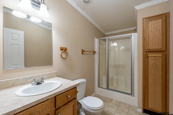 a bathroom with a sink a toilet a mirror and shower