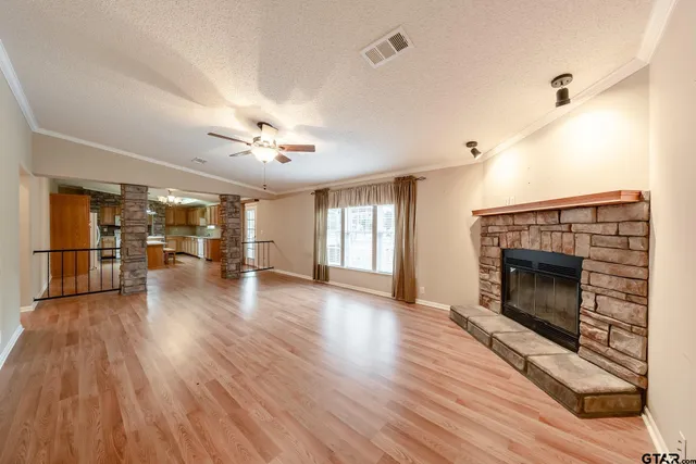 a view of a livingroom with wooden floor and a fireplace
