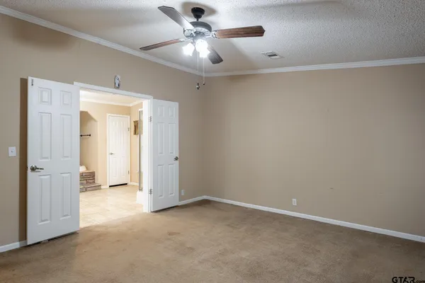 an empty room with a ceiling fan and a window