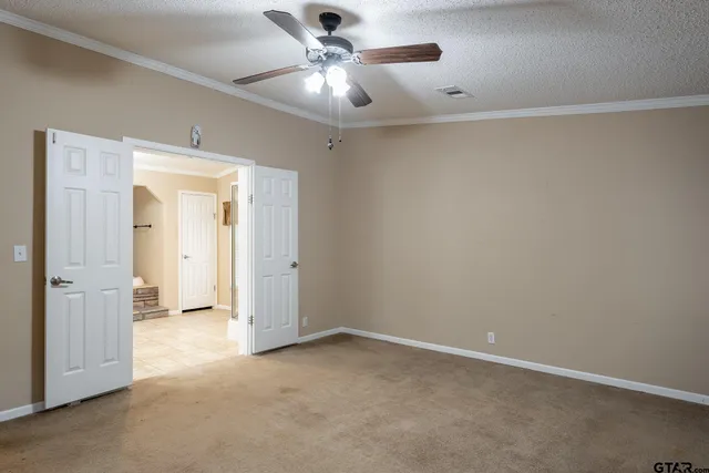 an empty room with a ceiling fan and a window