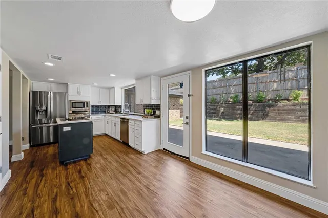 a kitchen with a refrigerator a counter top space and stainless steel appliances